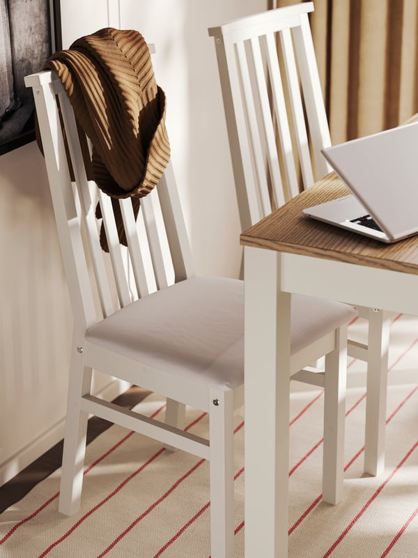 Two ÅLHULT chairs in beige with soft seats in Kabusa light beige placed next to a beige/brown ÅLHULT extendable table.