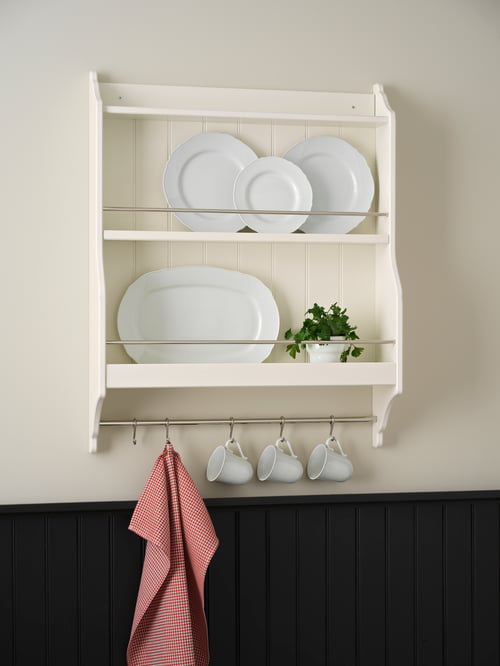 Kitchen with rustic white plate shelf with hooks, white plates with rounded edge, white mugs on hooks, pink guest towel.