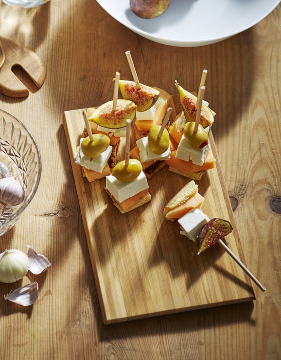 Planche à découper posée sur une table avec plusieurs assortiments de nourritures.