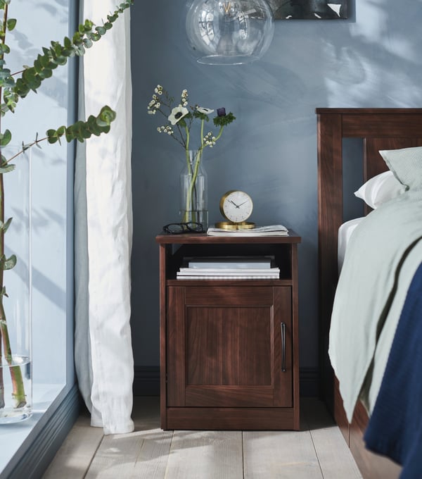 A brown SONGESAND bedside table in the bedroom