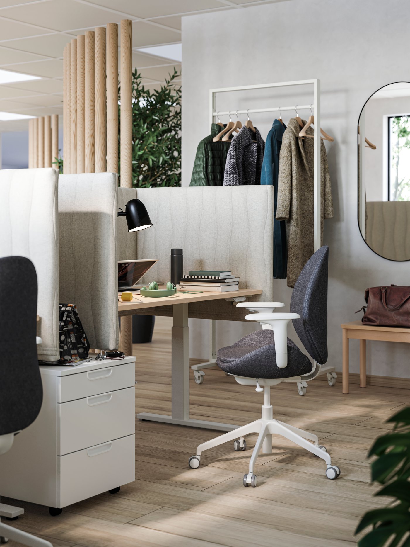 In a workspace there is a HATTEFJÄLL office chair with armrests positioned alongside a desk, and a drawer unit on castors.