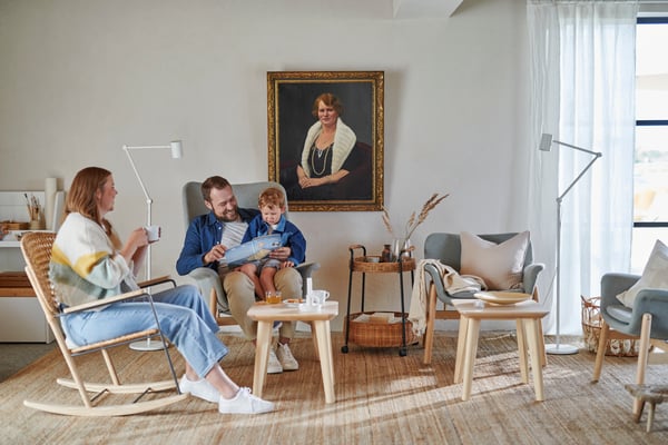 A family of three sitting together in their living room.