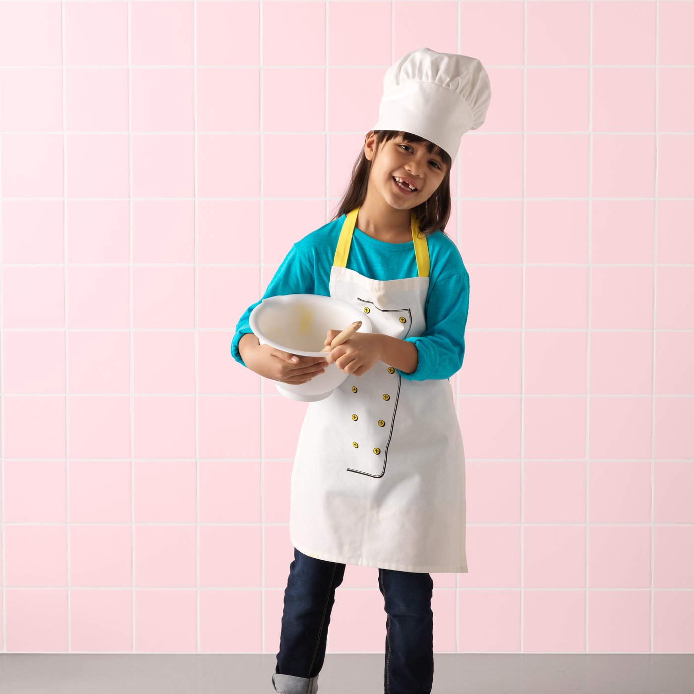 A white/yellow TOPPKLOCKA children’s apron with chef’s hat