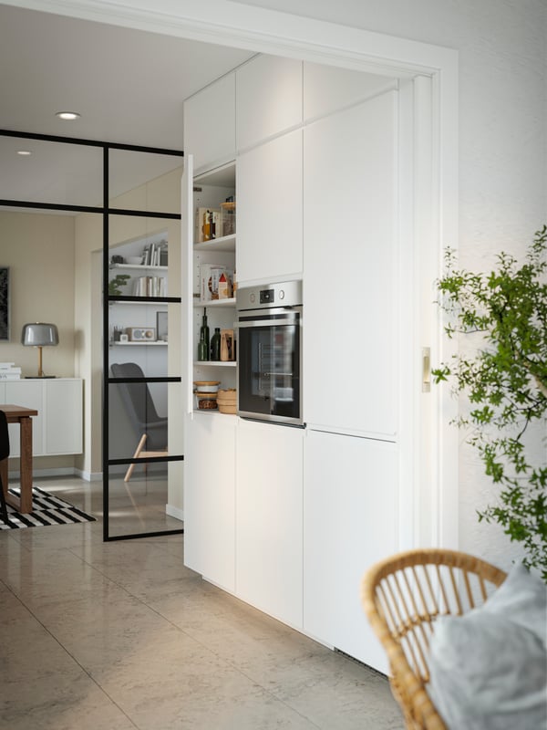 Cuisine blanche ouverte avec une porte verrière