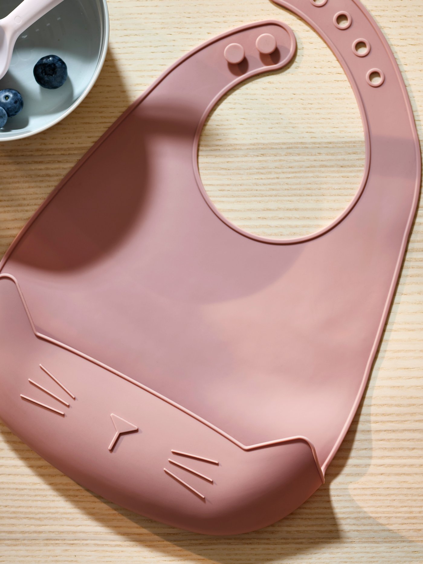 A pale pink GULDVÄVARE bib