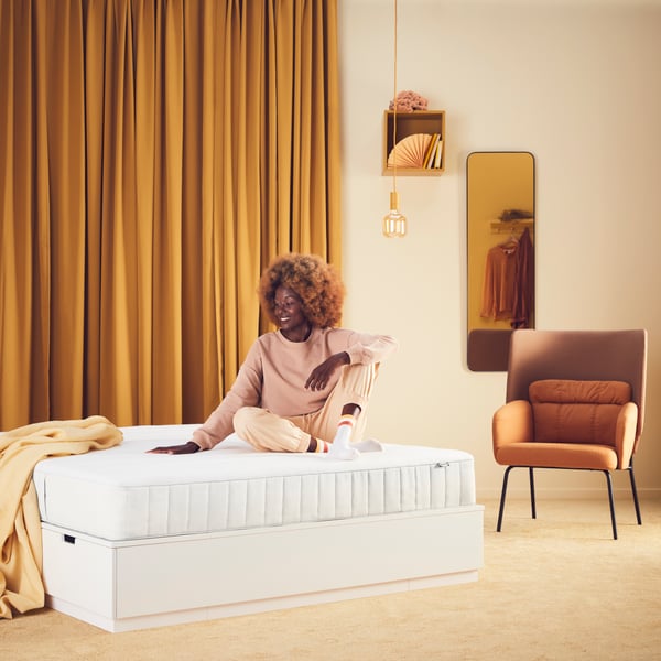 A firm/white VESTERÖY pocket sprung mattress in the bedroom