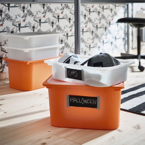 A TROFAST mesh storage box filled with toys is placed on the floor.