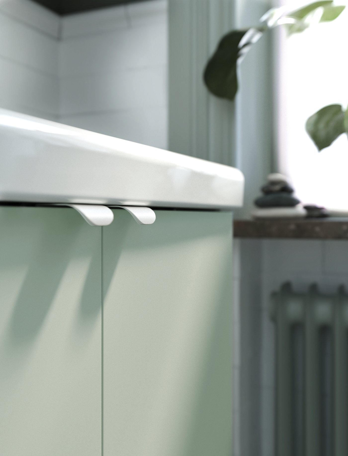 A TVÄLLEN washbasin single with ENHET doors in pale grey-green and BILLSBRO handles in white.