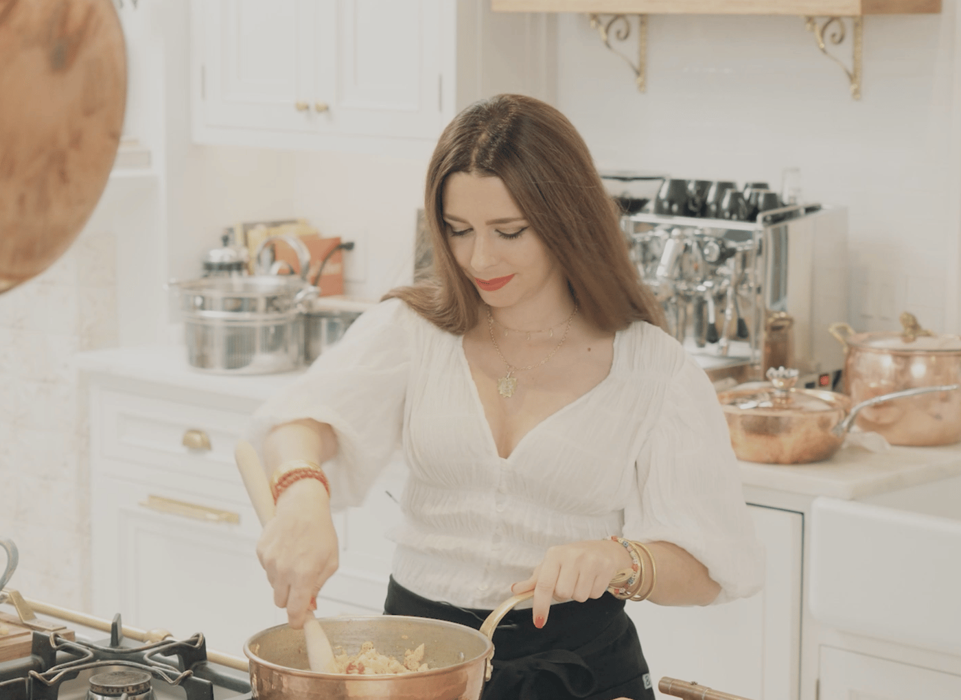 The Pasta Queen u kuhinji, posipa začine po sveže skuvanoj testenini na tanjiru.