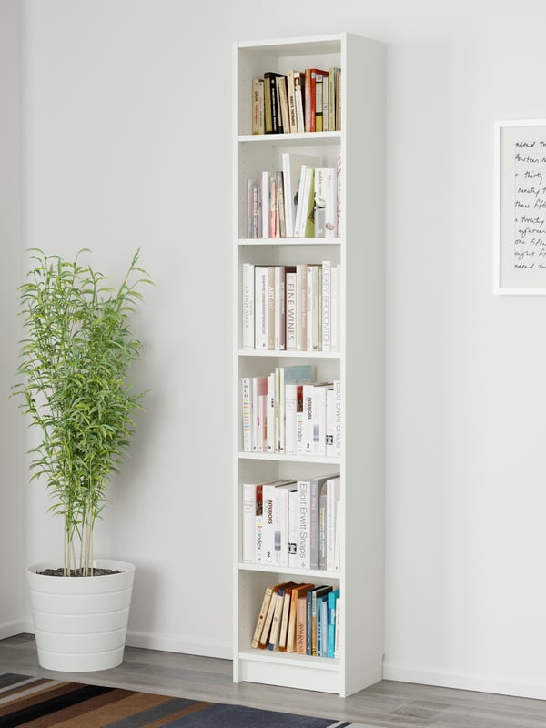 Ein weißes BILLY Bücherregal  40 breit, 28 tief und 202 cm hoch, steht vor einer weißen Wand. Daneben steht eine Zimmerpflanze. 