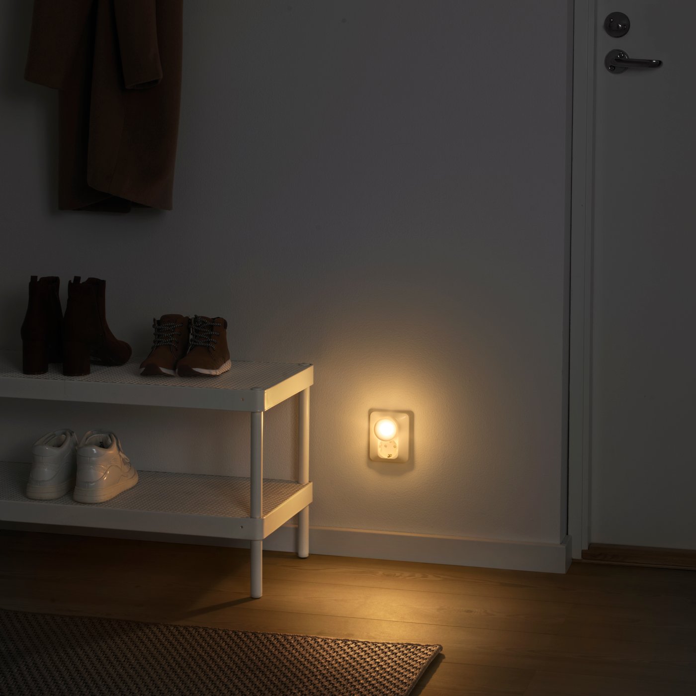 A MÖRKRÄDD night light with sensor in the hallway next to a shoe cabinet.