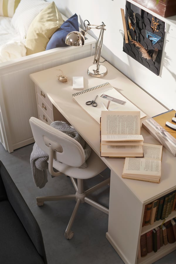 Ett beige skrivbord i traditionell stil skapar en fin arbetsstation i sovrummet. 