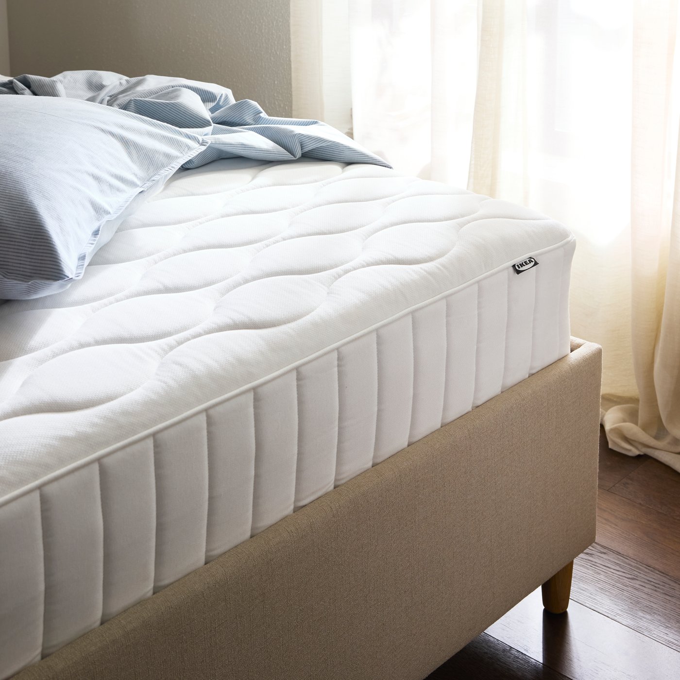 A firm/white VÅGSTRANDA hybrid mattress in the bedroom