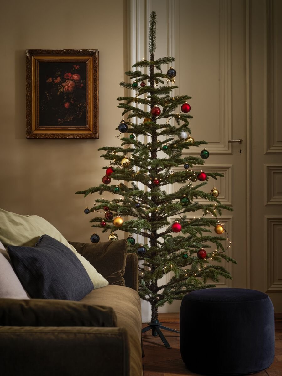 Grande albero di Natale in un soggiorno dallo stile tradizionale; i rami sono decorati con palline dai colori vivaci - IKEA