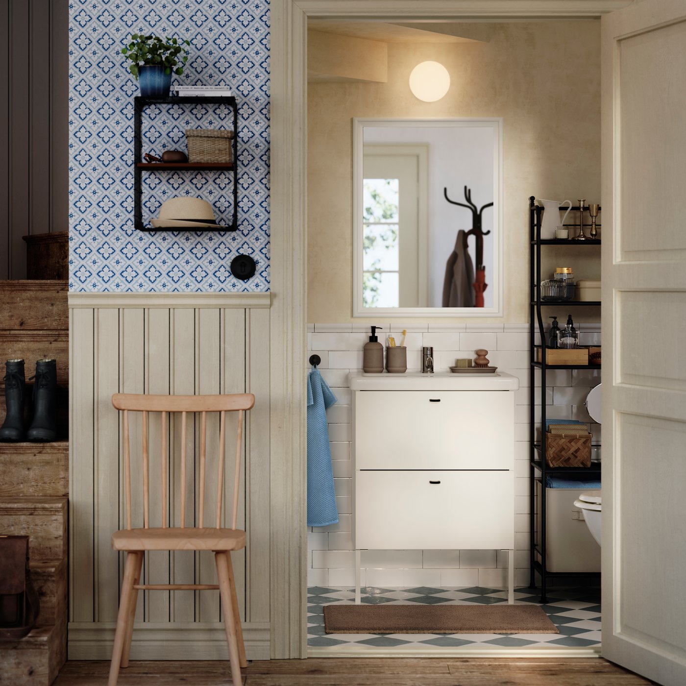 В традиционной ванной комнате под лестницей на кафельной стене стоит белый умывальник ENHET/TVÄLLEN с ящиками и ножками.
