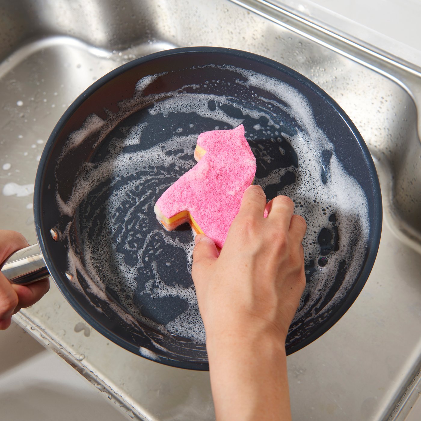 A close-up shot of a pink SNABBAKAT sponge in the shape of a Dala horse.