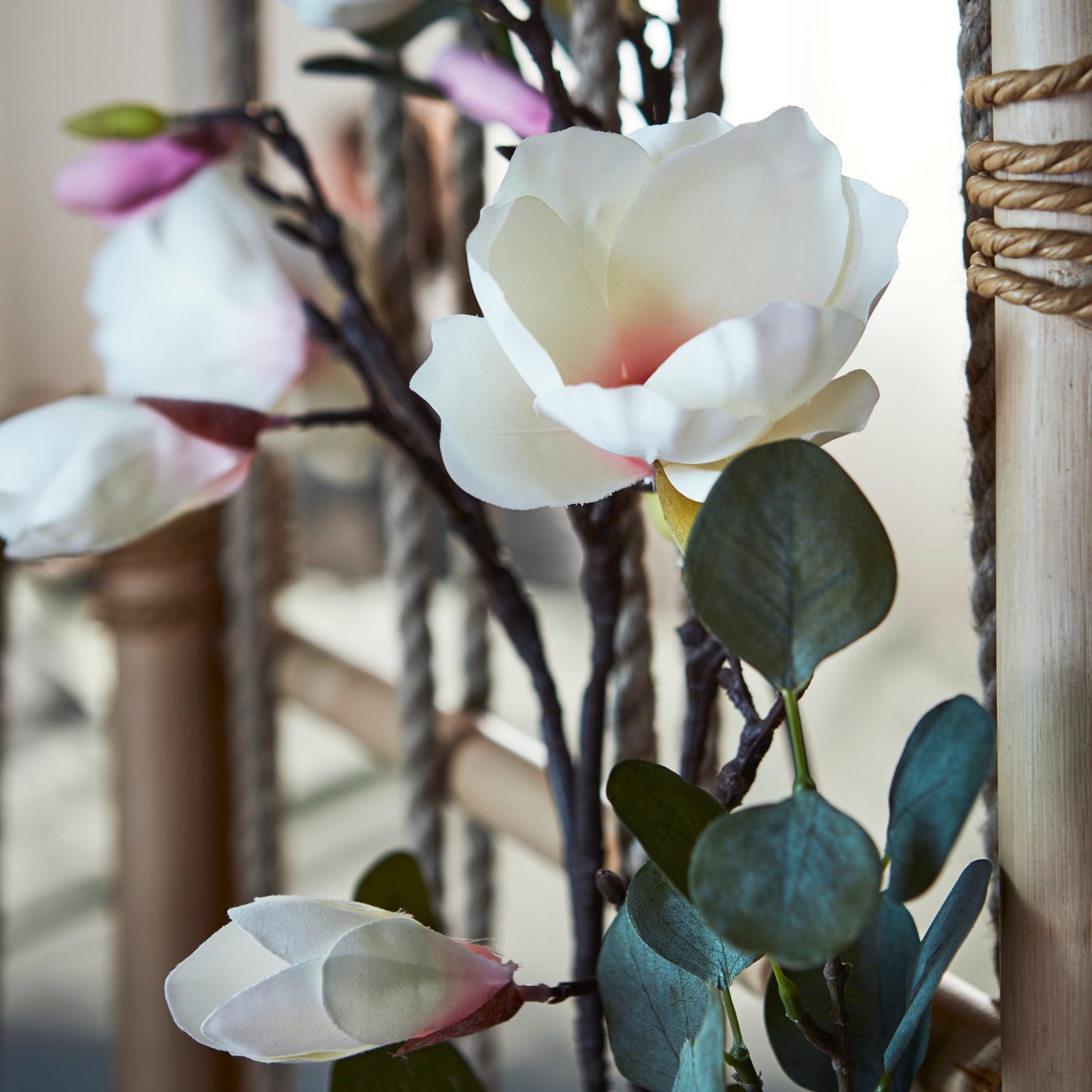 Teil eines TÄNKVÄRD Raumteilers, geschmückt mit SMYCKA Kunstblumen und -blättern (mit Schnur befestigt).