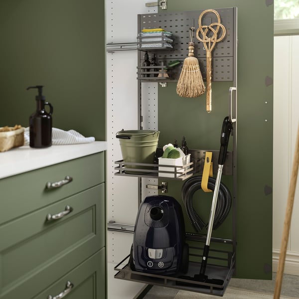 A cabinet door is open and there’s a UTRUSTA cleaning interior on the inside of the door with organized cleaning utensils.