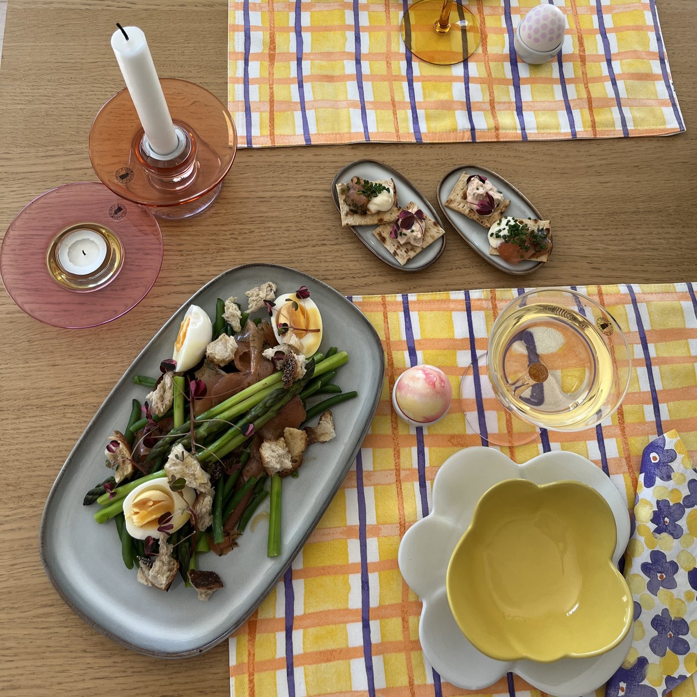 En laxsallad är upplagd på ett GLADELIG fat som ligger på ett dukat påskbord.