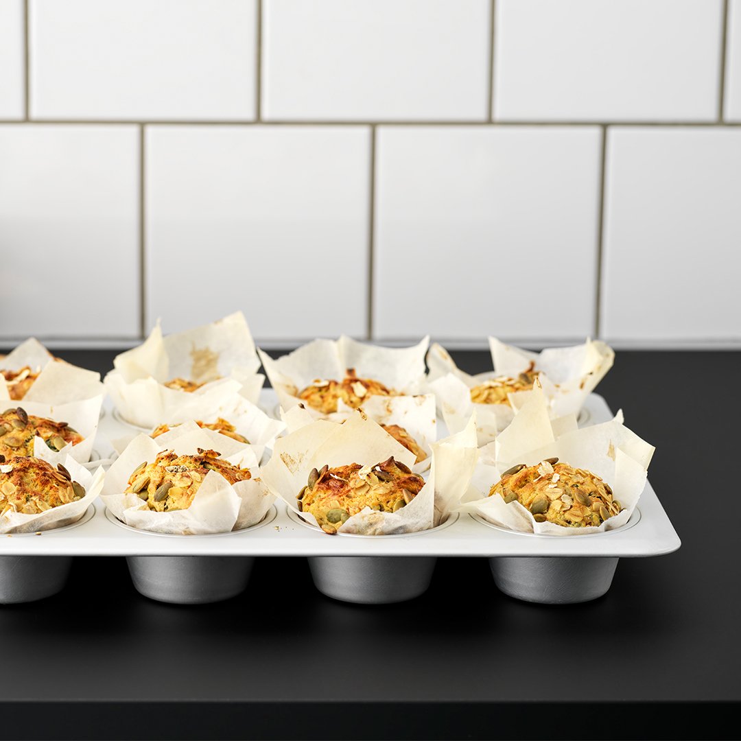 Muffiny w srebrnej formie VARDAGEN na ciemnym blacie kuchennym.