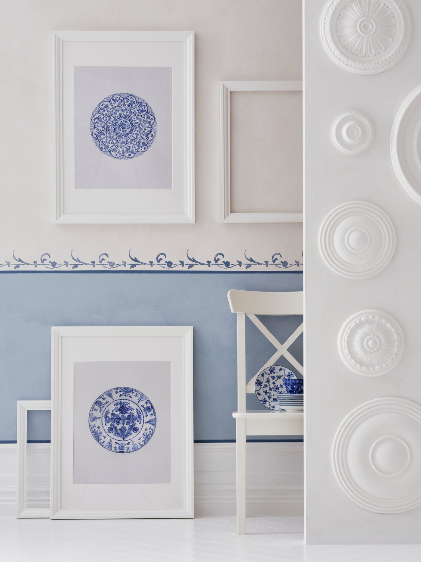 Cadre blanc avec des motifs bleu à l'interieur dans une pièce blanche