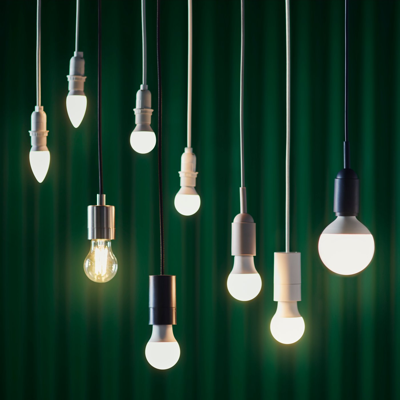 Nove lampadine a LED SOLHETTA appese al soffitto, davanti a una tenda verde.