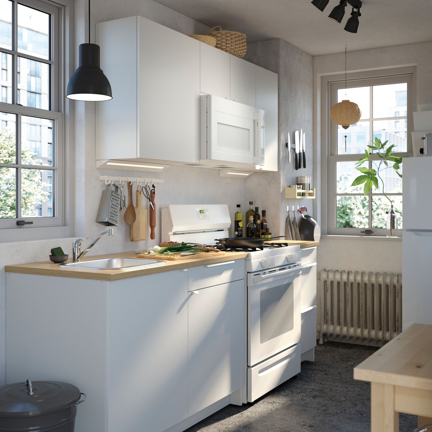 Une cuisine bien éclairée comprenant des armoires KNOXHULT en blanc, un comptoir en bois, des plantes et des électroménagers modernes.