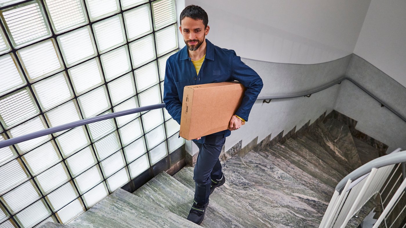 a person carrying a box up a flight of stairs