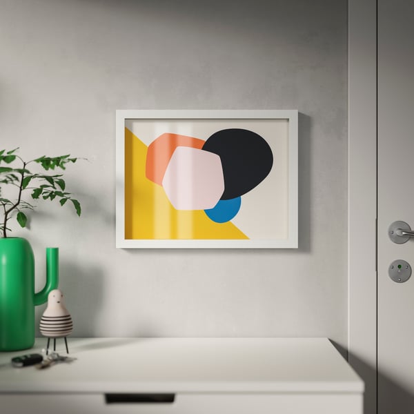 An IKEA RÖDALM white picture frame mounted on the wall on top of a sideboard in the living room. 