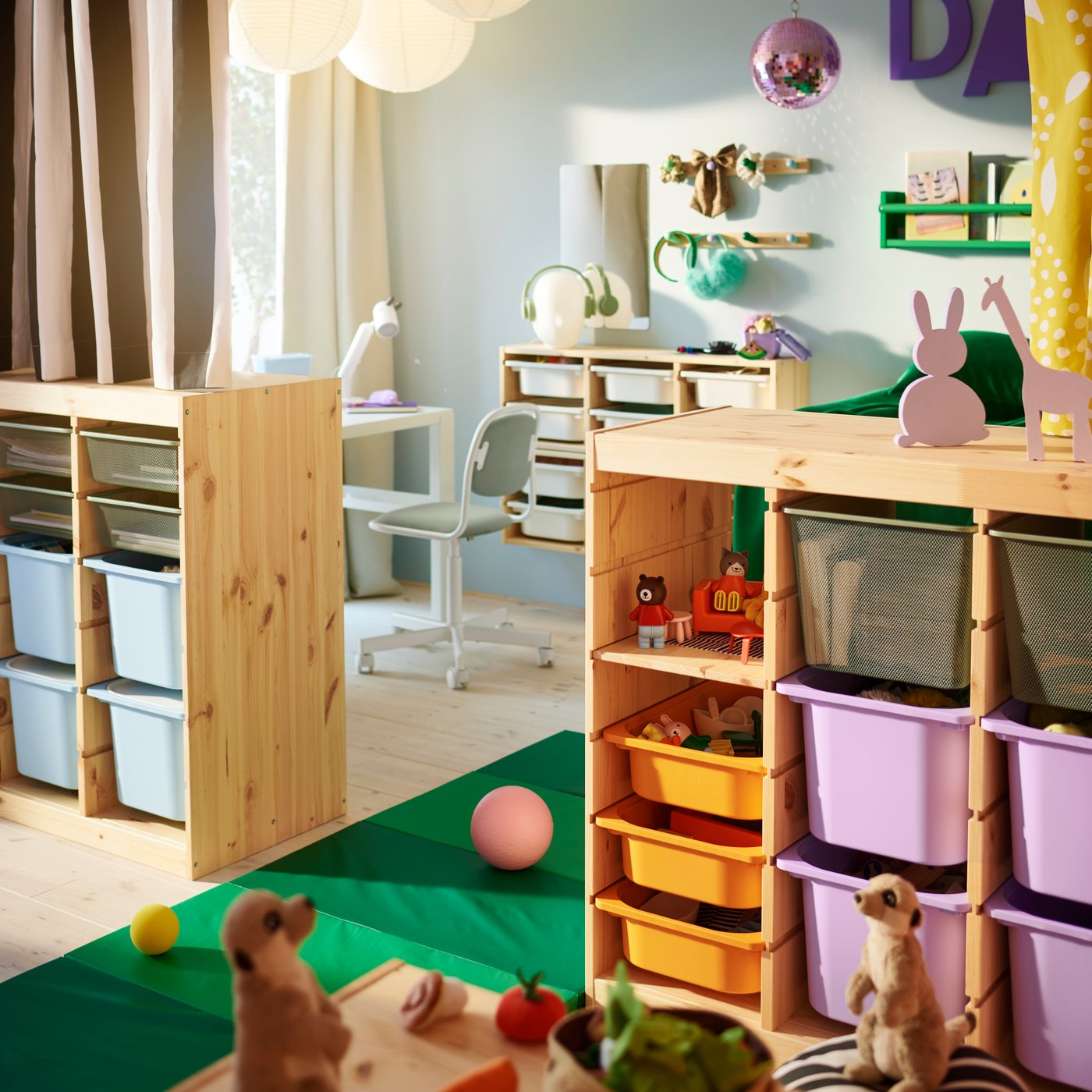 Two light white stained pine TROFAST room dividers holding a mix of coloured boxes in the middle of a children’s bedroom.