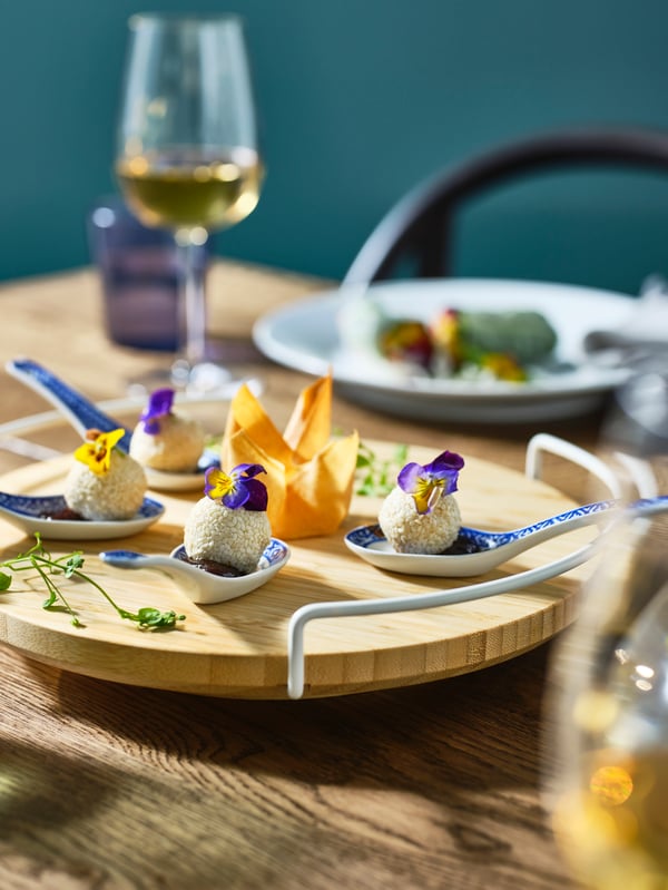 A wooden APTITLIG Lazy Susan with various bites.