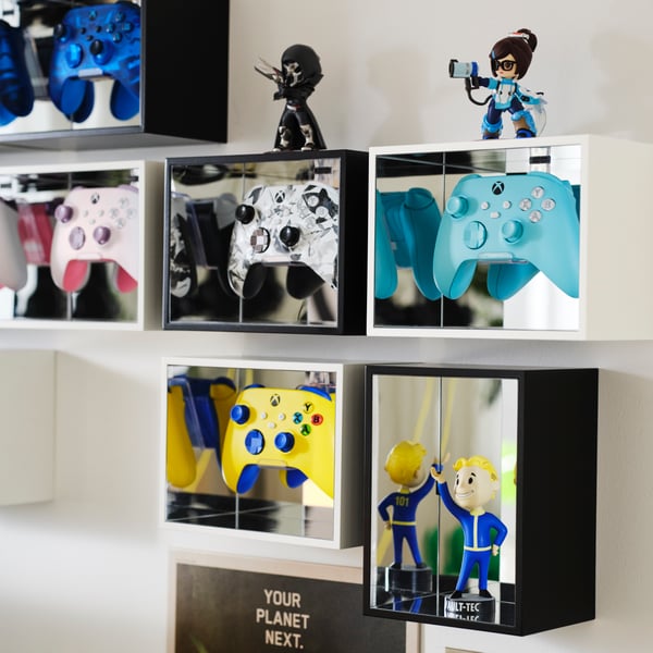 Sechs YXSTABY Gaming-Controller-Displayboxen hängen an einer weißen Wand und zeigen Controller in verschiedenen Farben und Sammlerstücke.