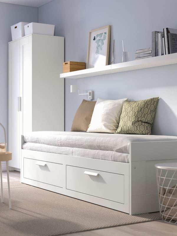 Una estructura daybed BRIMNES con 2 cajoneras en una sala de estar