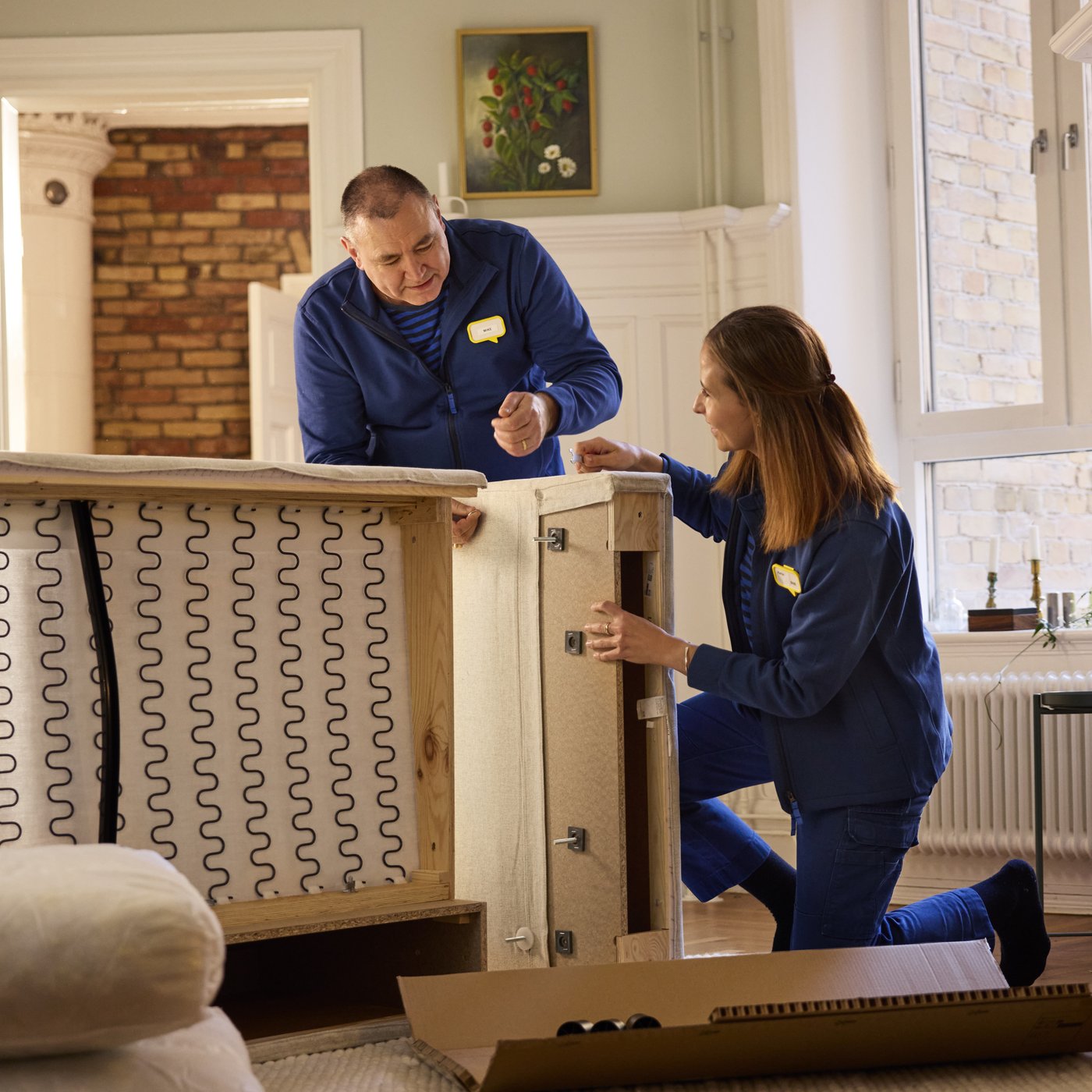 pracownicy ikea skręcają sofę
