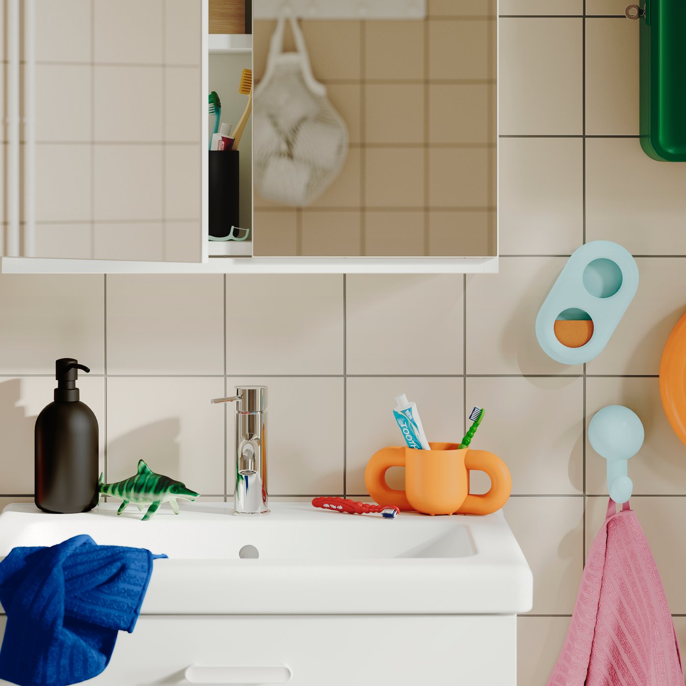 An orange HUMLESJÖN mug containing toothbrushes on a bathroom worktop beside a sink and soap dispenser.