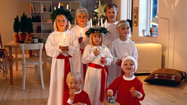 子どもたちが白い衣装を着てろうそくを頭につけている。