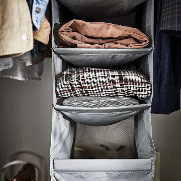 A dark gray SKUBB clothes organizer with 9 compartments full of winter items