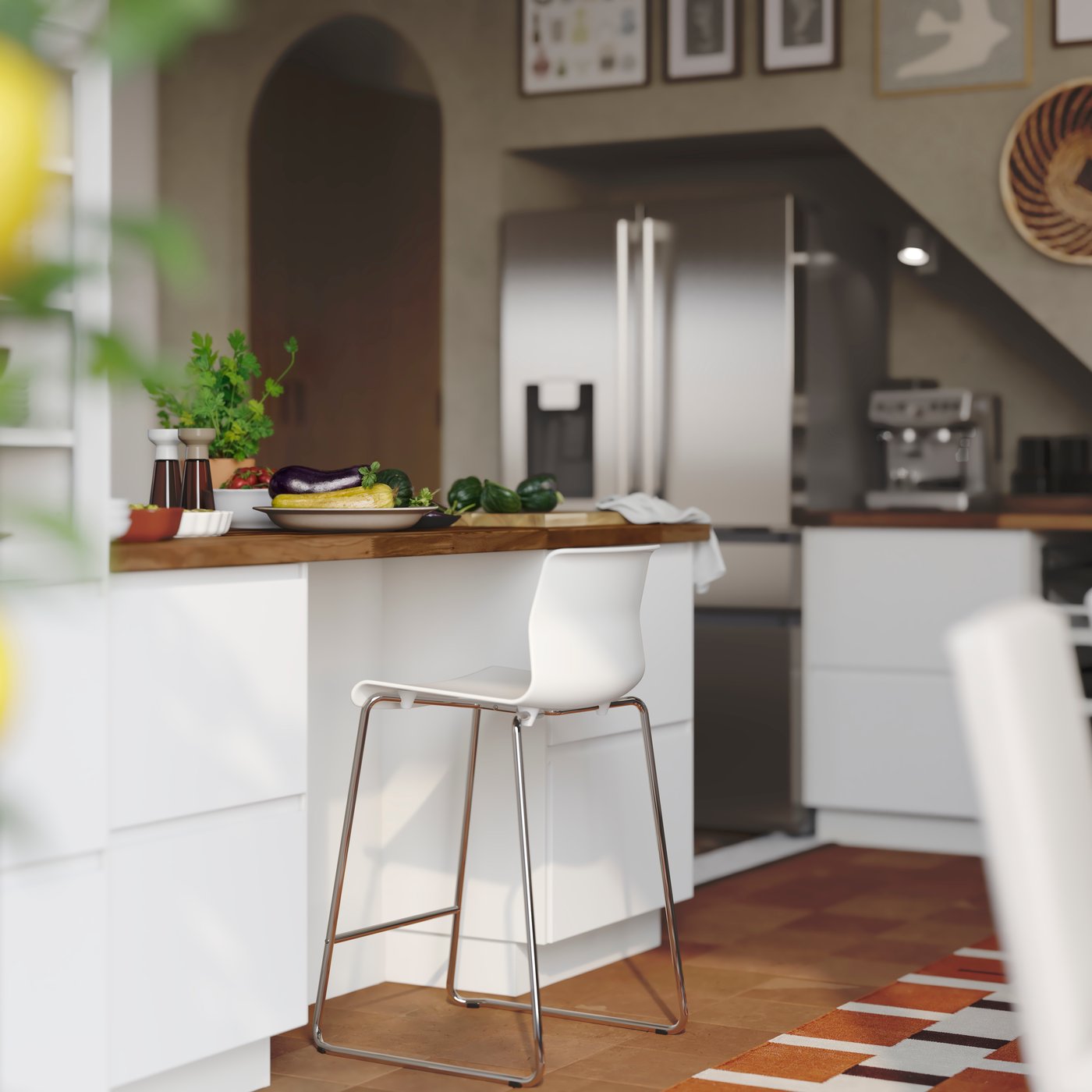 Tabouret de bar GLENN à côté d’une péninsule de cuisine avec du rangement dans des tiroirs aux faces VOXTORP en blanc mat.