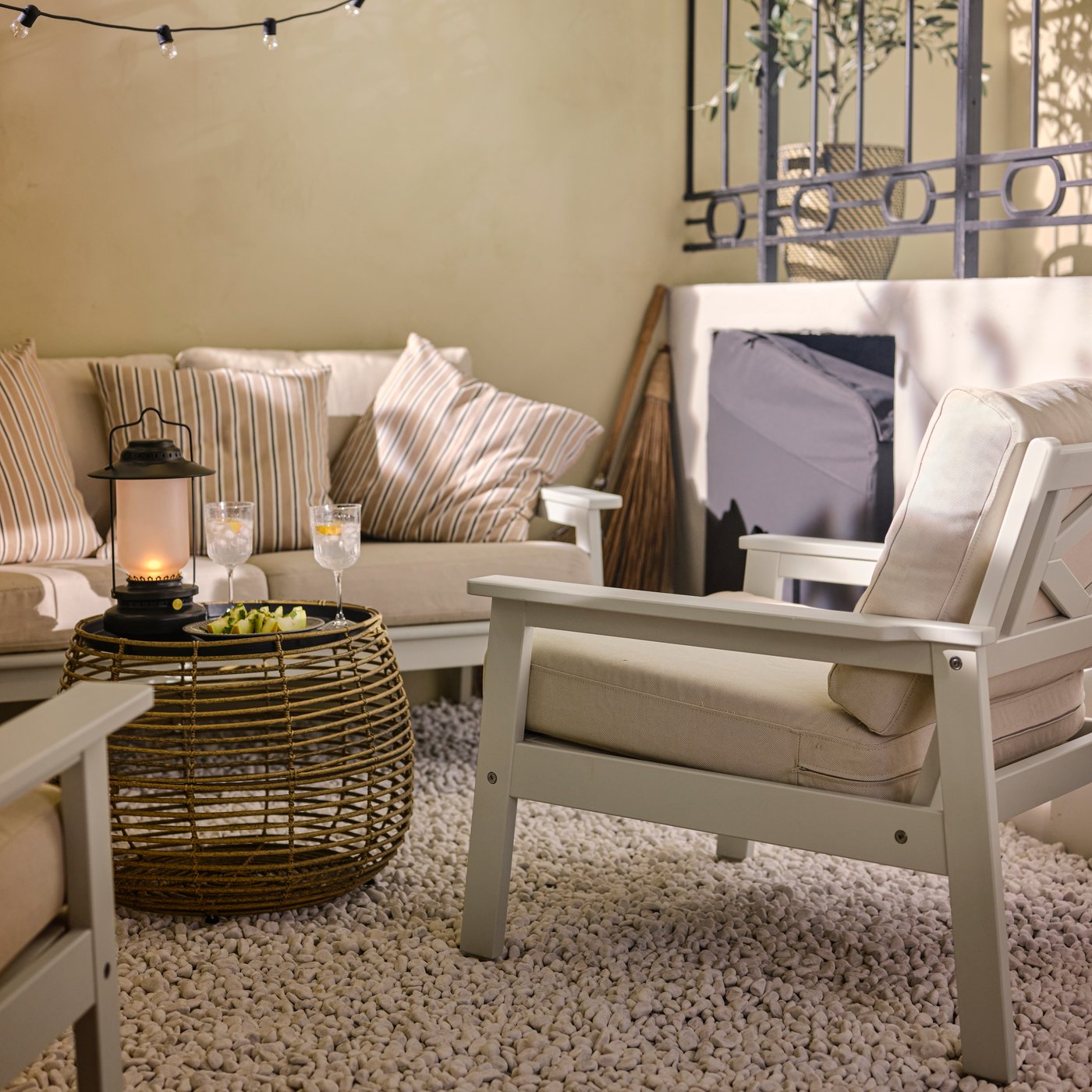 Kącik na zewnątrz z 2-osobową sofą BONDHOLMEN, dwoma krzesłami z regulowanym oparciem BONDHOLMEN i stolikiem kawowym FÅLSKÄR na białym dywanie.