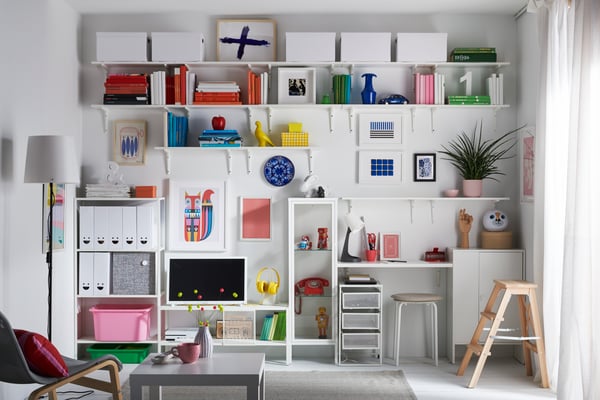 A living room with an entire wall with shelves and cabinets dedicated to books, toys, collectibles and magazine storage.