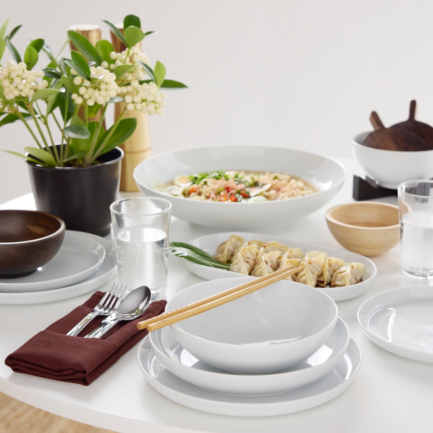A table set for a meal with food and an IKEA 365+ bowl, an IKEA 365+ serving bowl and a bamboo BLANDA MATT serving bowl.