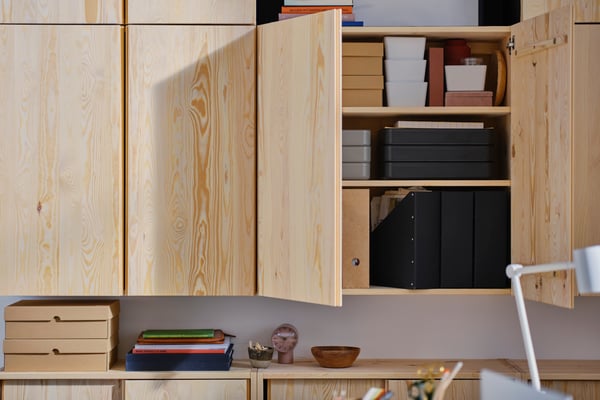 Ein IVAR Wandschrank mit Büromaterialien darin.