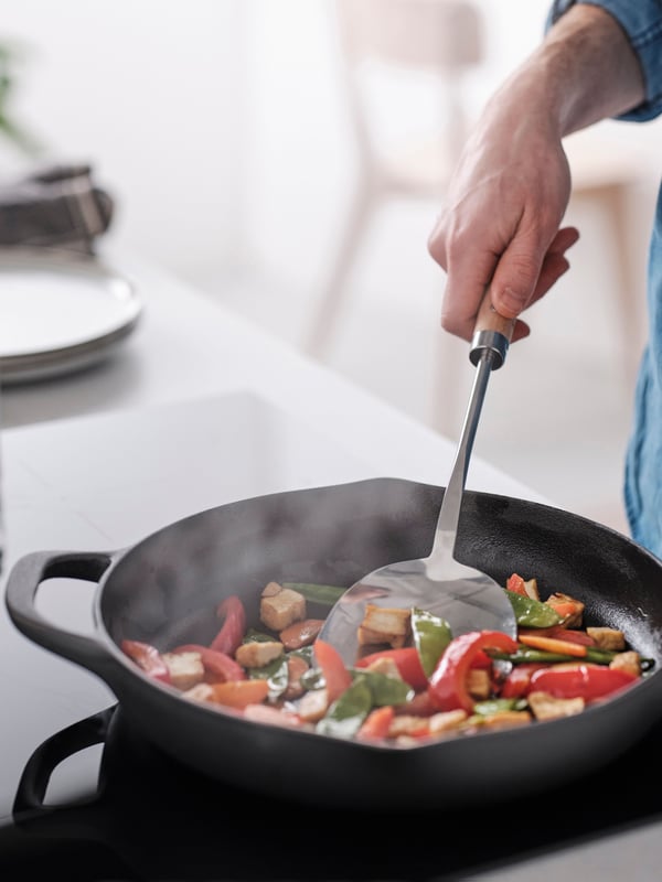 Un wok VARDAGEN en acier inoxydable/hêtre spatule