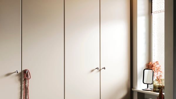 A white/grey-beige PAX wardrobe combination in the bedroom