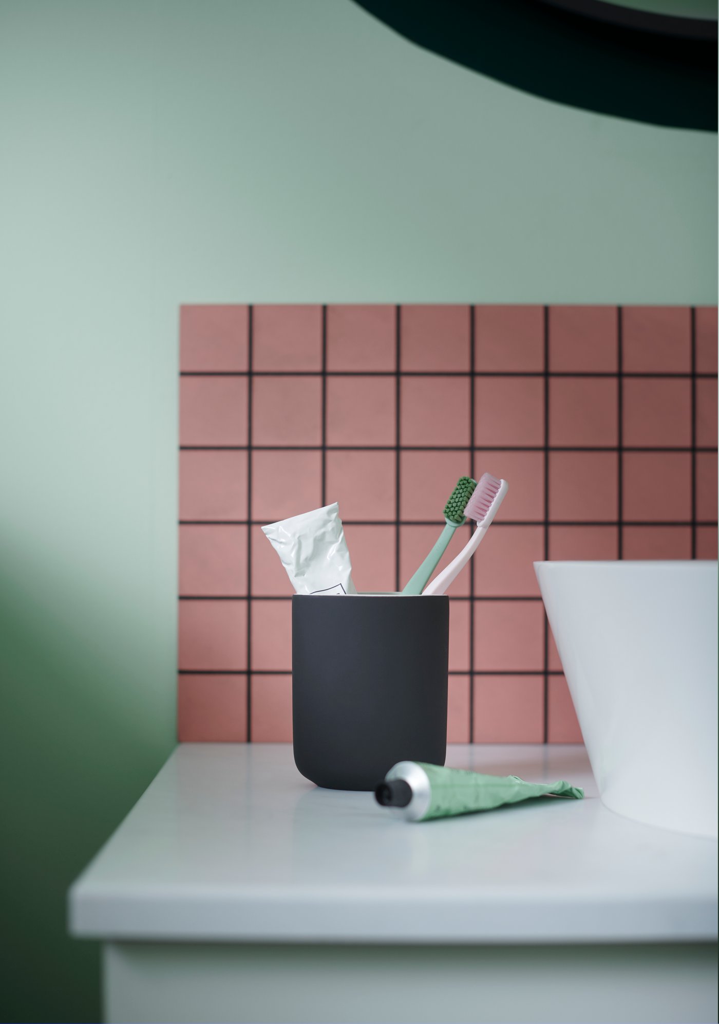 A dark grey EKOLN toothbrush holder in the bathroom