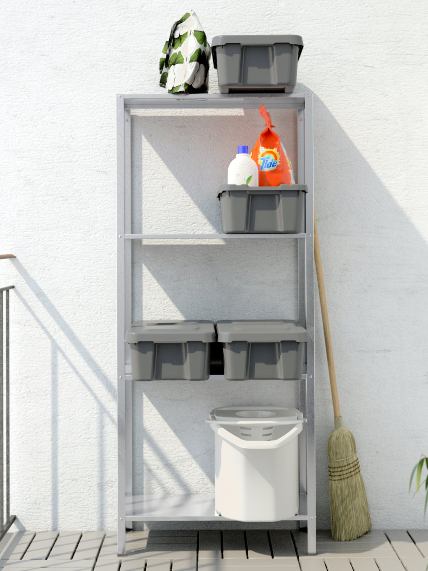 A HYLLIS shelving unit, on RUNNEN floor deck, against a white wall. On its shelves are four grey plastic boxes and a bucket.