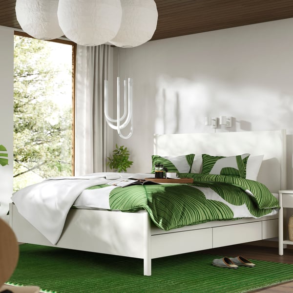 An off-white TONSTAD bed frame with storage