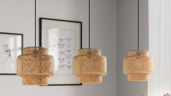 Three bamboo/handmade SINNERLIG pendant lamps hanging above a dining table.
