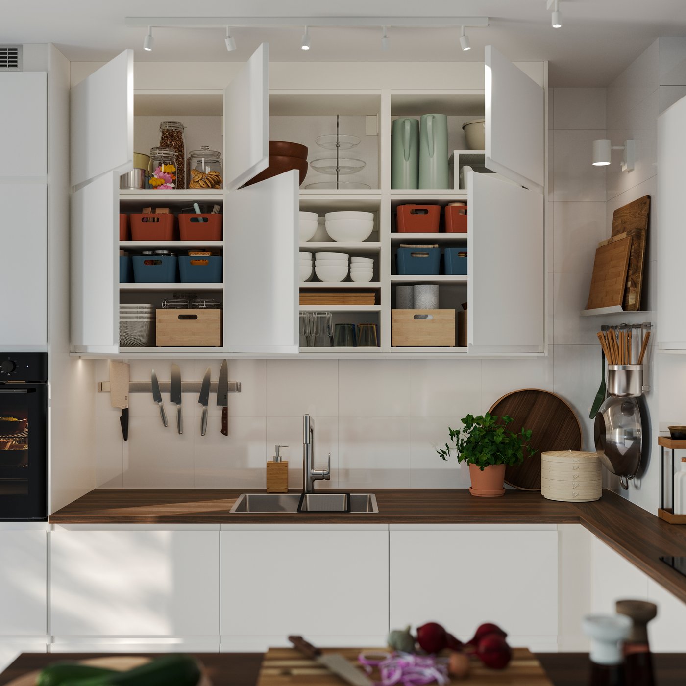 Wall-mounted kitchen cabinets have matt white VOXTORP doors and some of them have been opened, showing items stored inside.