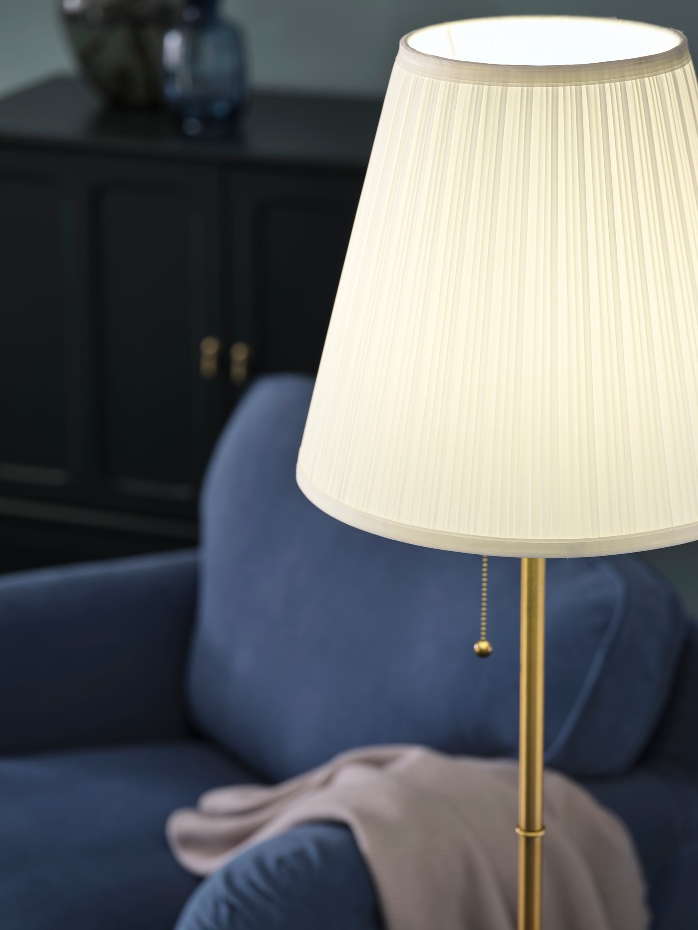 Lampadaire blanc au look classique à côté d'un fauteuil bleu